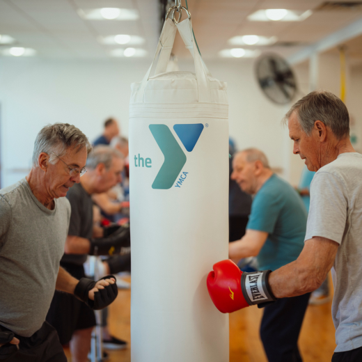 groups of older adults boxing in fitness class