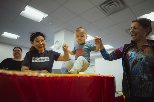 a group of people holding a baby up in the air